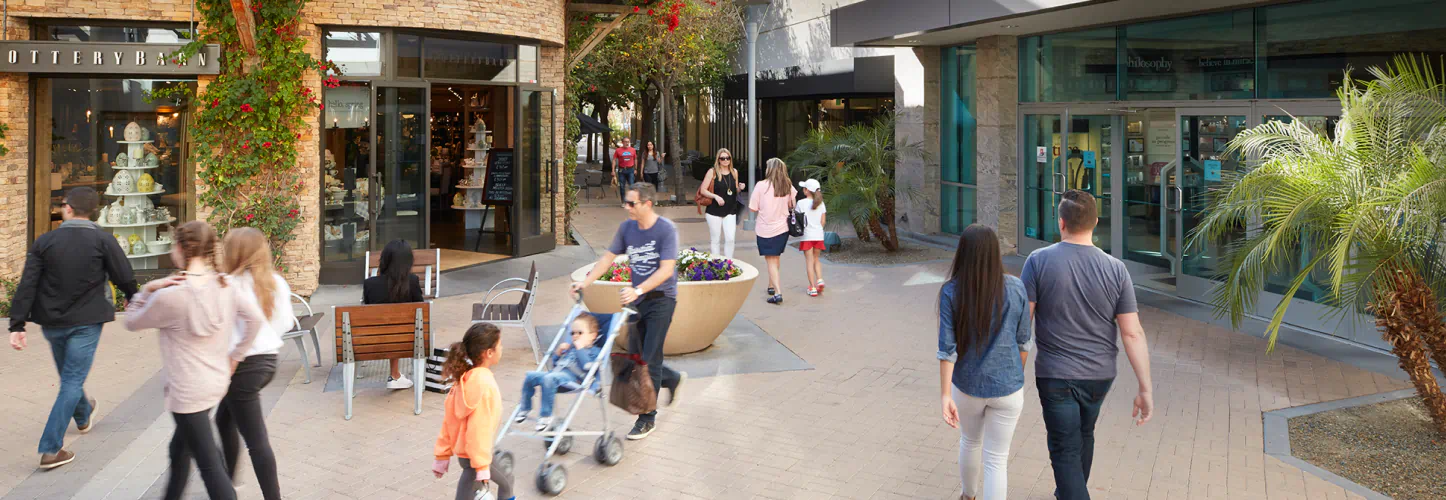 People walk past the many storefronts of Biltmore Fashion Park.