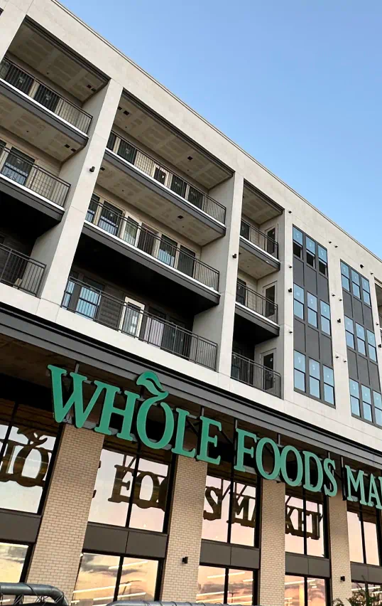 Exterior of Whole Foods Market with luxury apartments above.