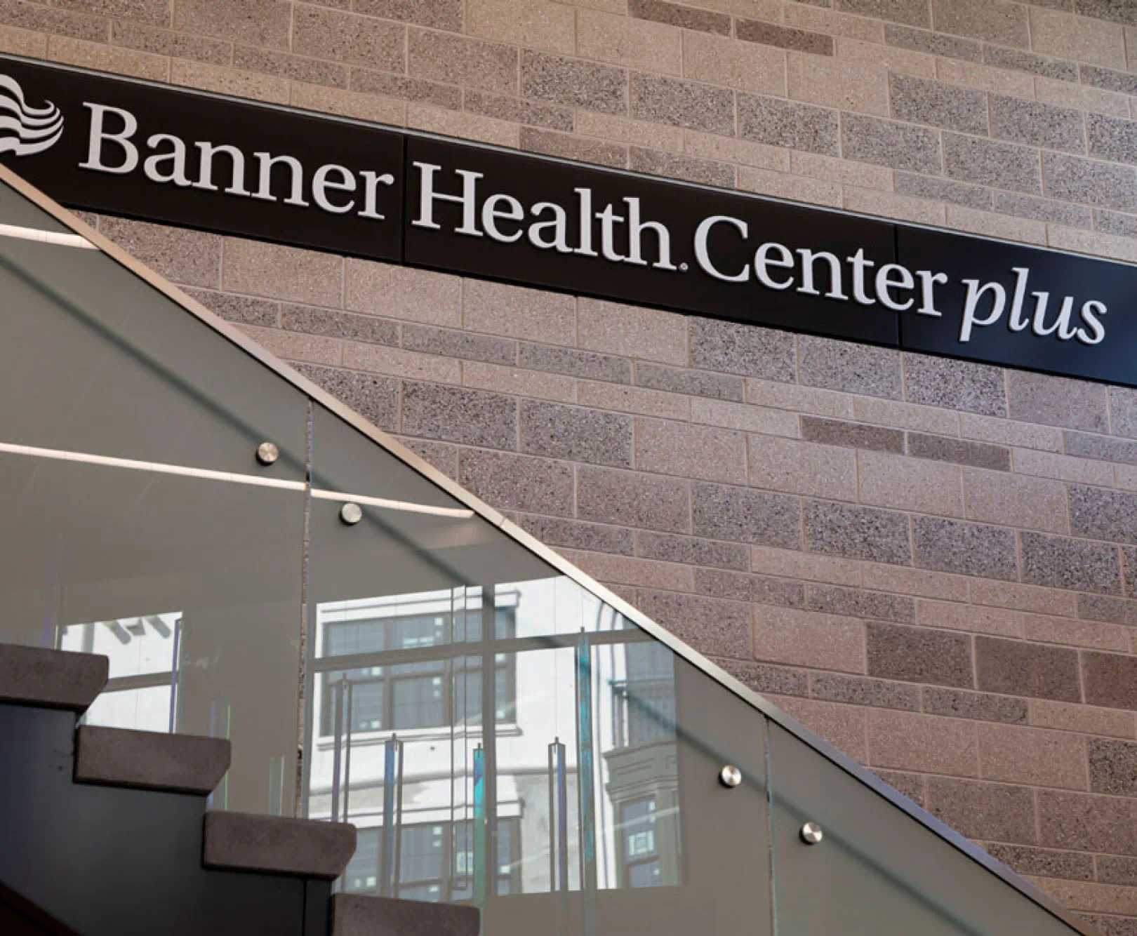 A brick wall with a Banner Health Center plus sign on it