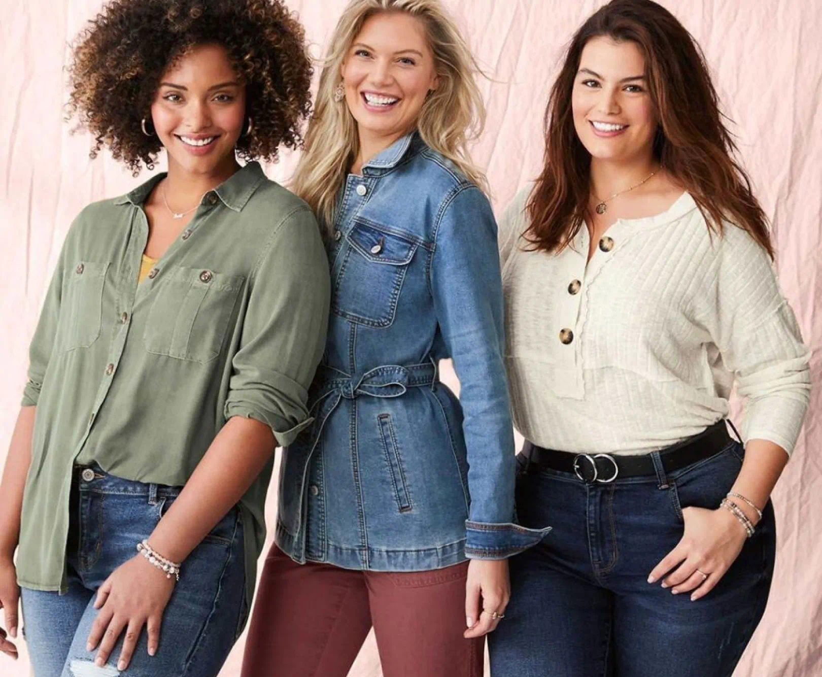 Three women stand side-by side, wearing casual wear.